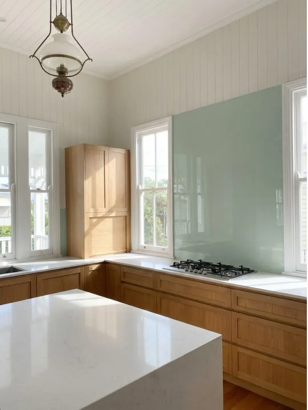 Seamless hygienic glass splashback installed in an bulimba kitchen renovation with modern finishes.